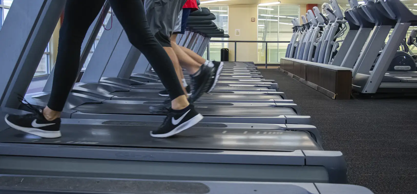 treadmill photo at gym with 3 people walking