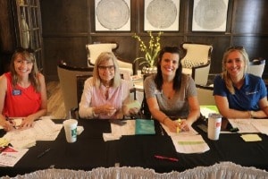 Four women advocates at a sign-up table