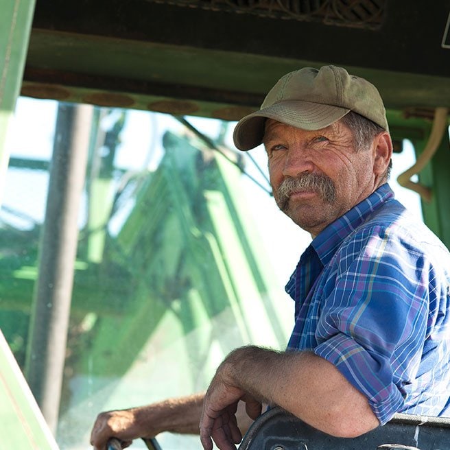 image of older man on a tractor