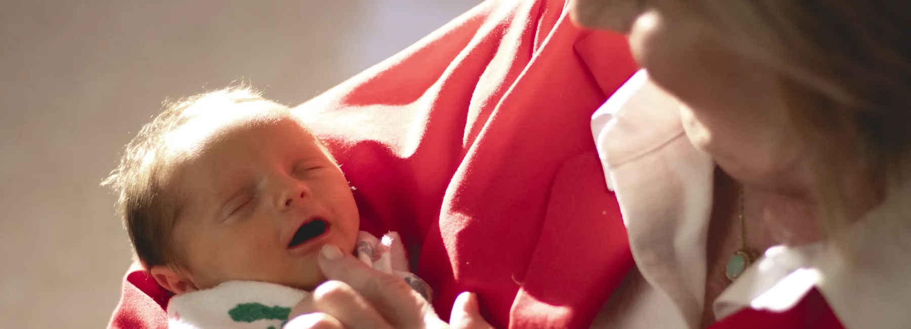 Volunteer snuggling a NICU baby