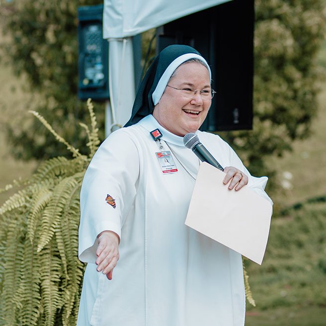 Image of Mother Mary Claire at Butterfly Release - butterfly landing on her arm